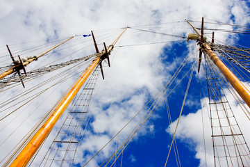 Tallship masts over cloudy blue sky