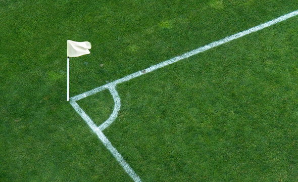 A corner flag on a soccer stadium green grass