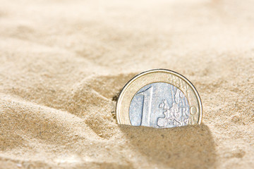 Euro coin in the sand