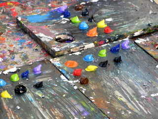 Palette en bois avec peintures à l'huile de toutes les couleurs.