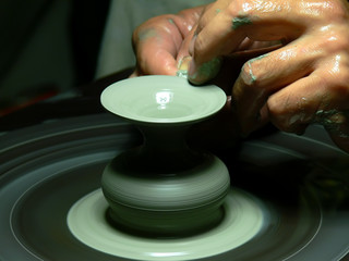 Potter's wheel with hands making a new pot