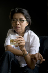dark portrait of a woman holding an alcoholic drink