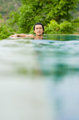 A young man relaxing in a swimming pool