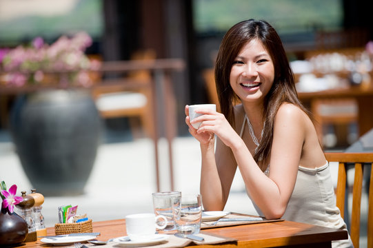 A young woman sitting alone at breakfast table at resort