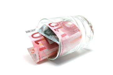Some euro banknotes in a tumbler isolated on white background