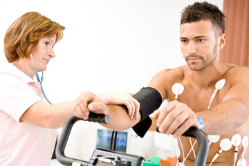 Nurse makes the patient ready for medical EKG test.