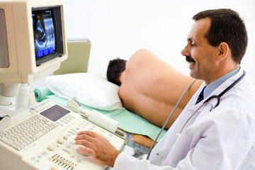 Doctor performing an ultrasound heart scan on  young male