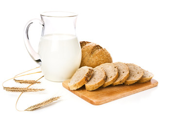 Jug with milk, bread and wheat