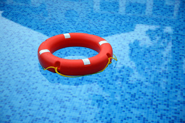 Red life buoy floating in swimming pool