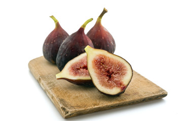 three whole figs and one sliced one isolated on white
