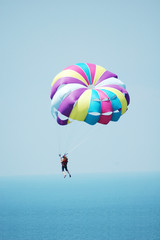 Multi coloured parachute over the blue sky