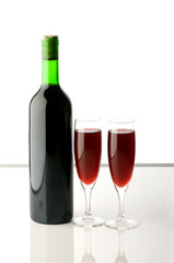 Bottle and wine glasses on reflective background