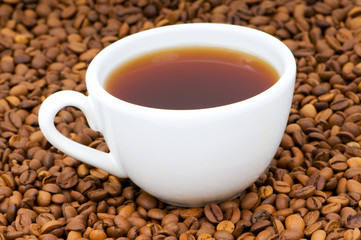 White cup on the background of coffee beans