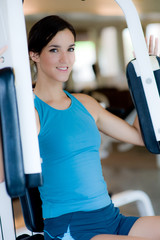 A young woman working out on a machine in a gym