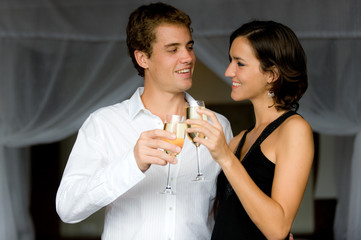 An attractive couple in bedroom with champagne