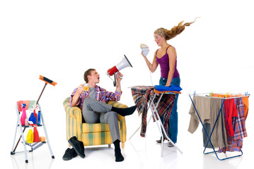 Young bossy man with megaphone,  woman ironing clothing