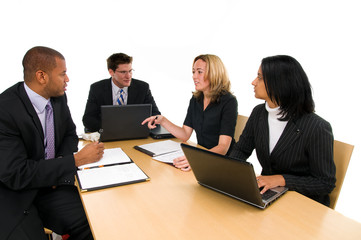 Two women and a two men sit at conference table