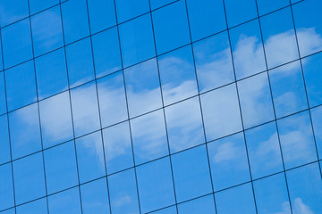 Mirror facade of a building with reflection of the sky