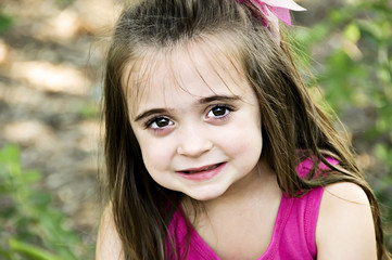 Beautiful brunette child smiling with big brown eyes.