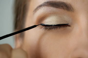 Close-up shot of work of make-up specialist. Low-focus image.