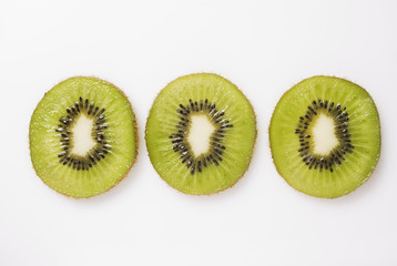 Three slices of kiwi fruit on white background