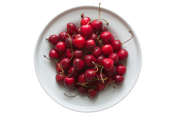 sweet cherries on porcelain plate isolated on white