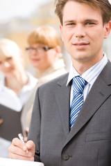 Portrait of male professional on background of businesswomen
