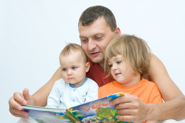 young father reading fairy tale to children