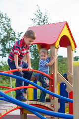The boys climb on the equipment of a playground