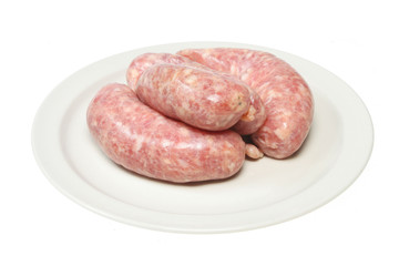 Raw pork sausages on a plate isolated on white