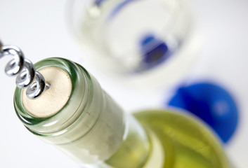 Bottle of white wine, glass ready waiting in the background