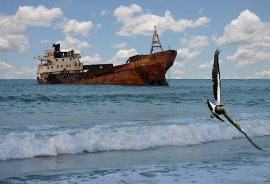 A partially sunk ship rusted by time on a remote coast