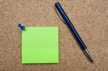 Photo of note posted and pen to a cork board