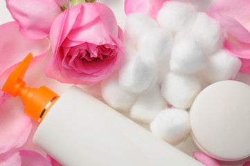 Blank skin care lotion with rose petals and cotton swabs