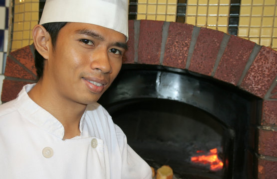 Chef At Front Of Pizza Oven Restaurant