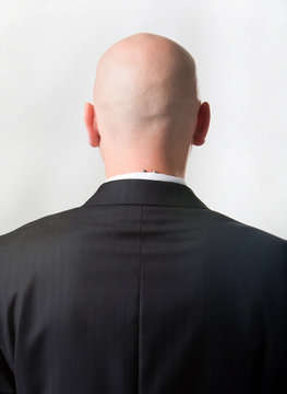 Rear view of bald man wearing suit over white background