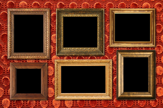 Antique frame collection on luxurious red velvet wall.