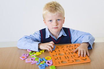Young boy with letters jigsaw