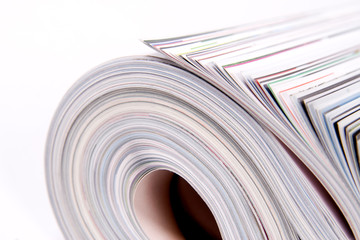 Three color magazines rolled on white background