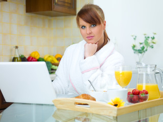 Obraz na płótnie Canvas Beautiful woman in kitchen eating tasty breakfast
