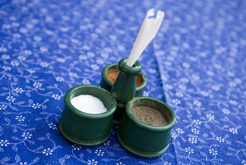 Closeup of dish for salt, peeper and paprika on table