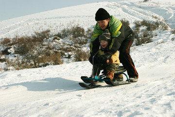 Fototapeta na wymiar Skiing with slides. Father Together with son.