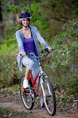 Fototapeta premium A young woman riding a bicycle in the woods