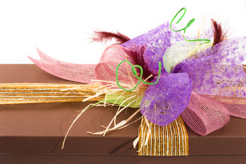detail of present box decorated with ribbons and feathers