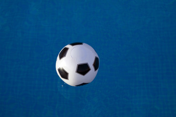 Fototapeta na wymiar inflatable plastic ball floating on a calm swimming pool