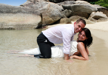 Bride and groom in the ocean during trash the dress session.