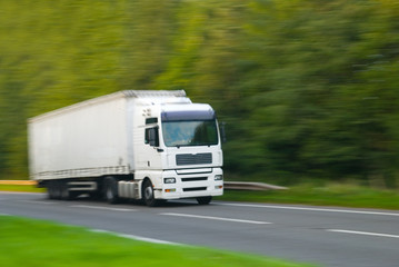 Large plain white truck with motion blur (in camera effect)