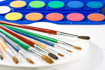 Obraz premium Water colour paints and brushes on a white background