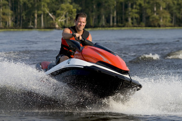 Man riding wave runner in river enjoying a nice summer day.
