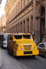 Fototapeta premium Camion de transporte de caudales amarillo en la ciudad